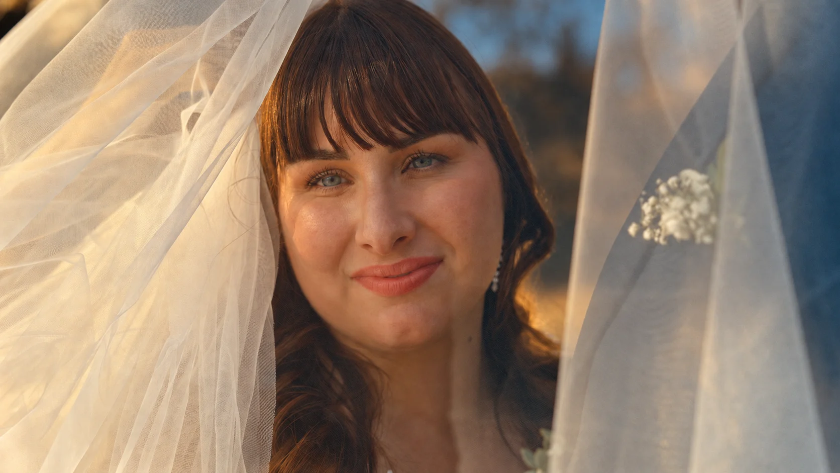 Portrait d’une mariée regardant l’objectif à travers son voile