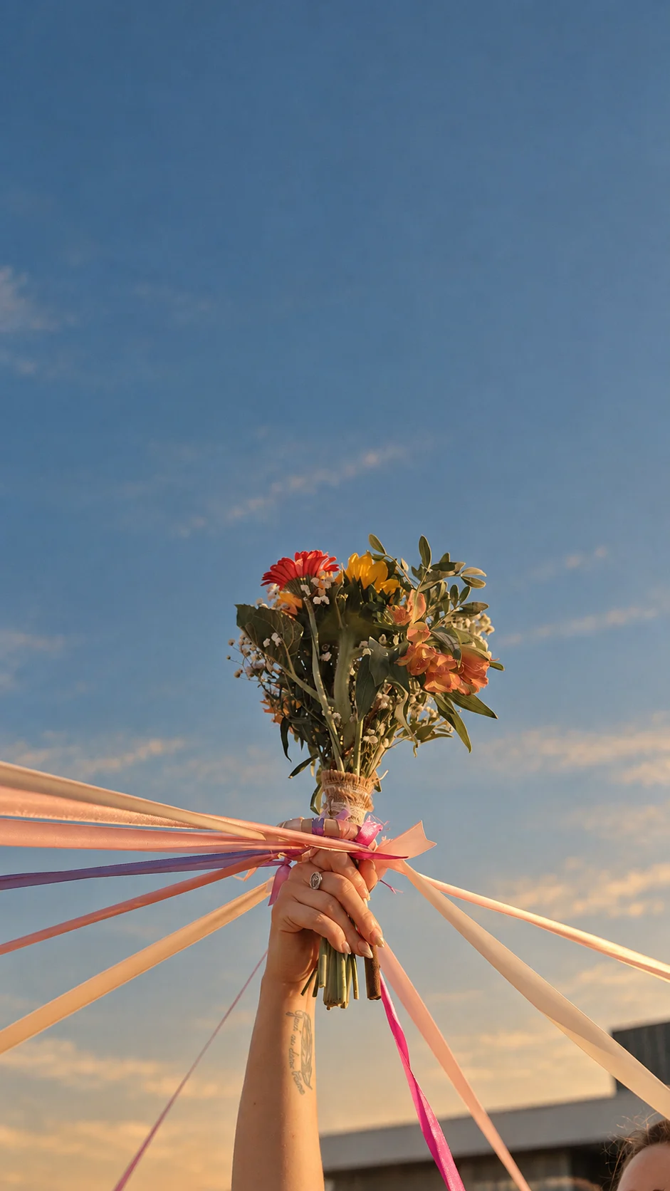 Bouquet de mariée et rubans levés vers le ciel